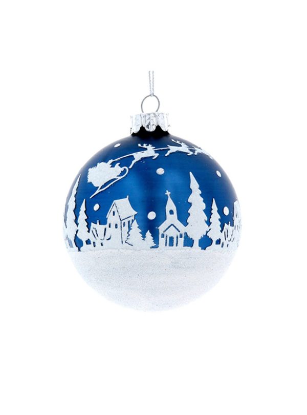 A midnight blue bauble with a fabulous white winter scene adorning the midnight blue setting. The winter scene is made up of a bed of snow along the bottom of the bauble with little houses, churches and trees upon the 'bed' of snow. Santa, his sleigh and the reindeer are climbing through the sky over the roof tops and snow is falling from the sky. The bauble in this photo is set against a white background.