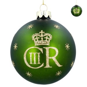 A matt green glass Christmas tree bauble featuring the Royal Cypher of King Charles III in Gold glitter. It the top right corner is a smaller image showing the reverse of the bauble featuring a gold crown. This matt green bauble features the royal cypher of King Charles III in gold glitter on one side and the Kings crown on the other with gold snowflakes around.