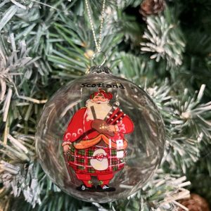 This hand painted round, clear glass Christmas bauble features a jolly Scottish Piping Santa on both sides. He is dressed in traditional Highland Regalia, complete with kilt and sporran! Scribed with the word 'Scotland' three times around the neck this baubles bring a lovely touch of Scotland to your Christmas Tree or a thoughtful gift for a far-from-home Scot!