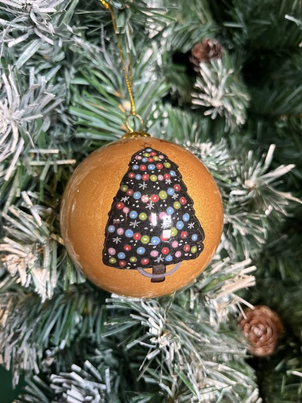 A gold glass Christmas tree bauble decorated with a hand painted image of a colourful Christmas tree decorated with lots of baubles and stars hanging on a Christmas tree.