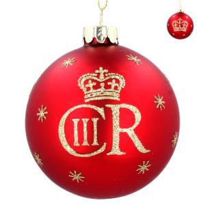 Majestic King Charles III Royal Red Glass Bauble. Celebrate the Coronation of King Charles III with this Regal King Charles III Royal Red Glass Bauble by Gisela Graham. This matt red bauble features the royal cypher of King Charles III in gold glitter on one side and the Kings crown on the other with gold snowflakes around. A perfect give for the Royalist in the family!