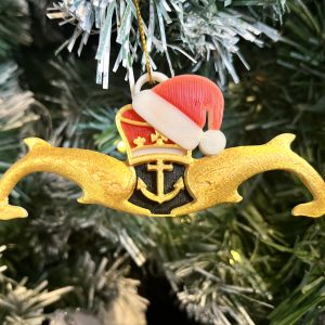 3D Printed Gold Submariners Dolphins with Santa Hat Tree Decoration Made locally, these 3D Printed Gold Submariners Dolphins Tree Decorations are the perfect Christmas gift for  the Submariner or sailor in your life. The measure 12cm x 4cm and feature red, white and black detail behind the crown and anchor with a red and white Santa hat ahnging off the crown at a jaunty angle. Supplied on a gold string ready for hanging on the tree.