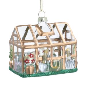 A glass Christmas tree bauble designed to resemble a 3D greenhouse with gold frame and clear glass windows featuring small plants and gardening tools within.