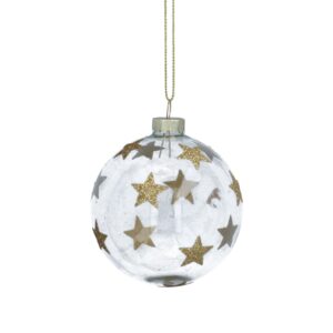 A clear Christmas ornament with gold glitter stars hangs from a thin gold string, catching the light.