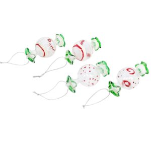 Four glass Christmas ornaments shaped like wrapped candies with green ends, decorated with red and white patterns, each featuring a silver hanging string.