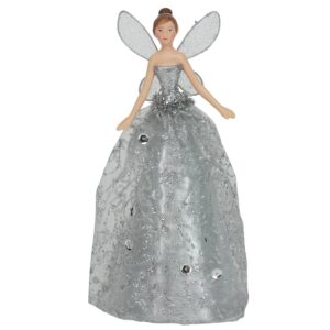 A figurine of a fairy with beige wings and a glittery pale gold dress adorned with sequins, standing upright.