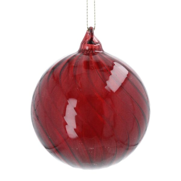 A glossy red glass Christmas tree bauble with a swirling pattern, suspended by a thin silver string.