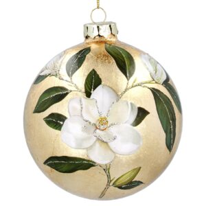 A large brushed effect gold Christmas ornament with a painted white flower and green leaves design embellished with silver glitter veingin on both the leaves and the flower